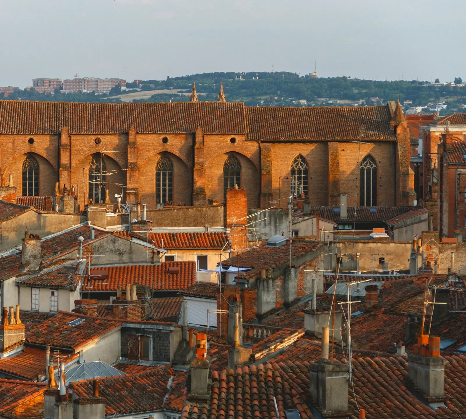 Toits de tuiles et église en brique de Toulouse dans la lumière du soir